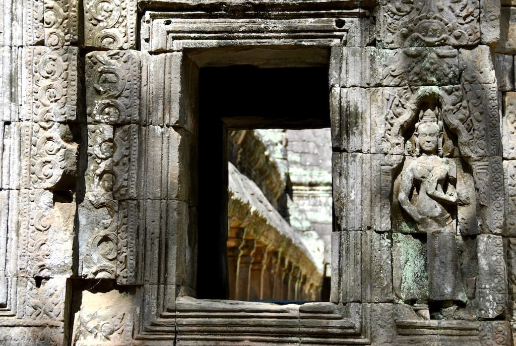 A closeup of a window and bas-relief in Ta Prohm.