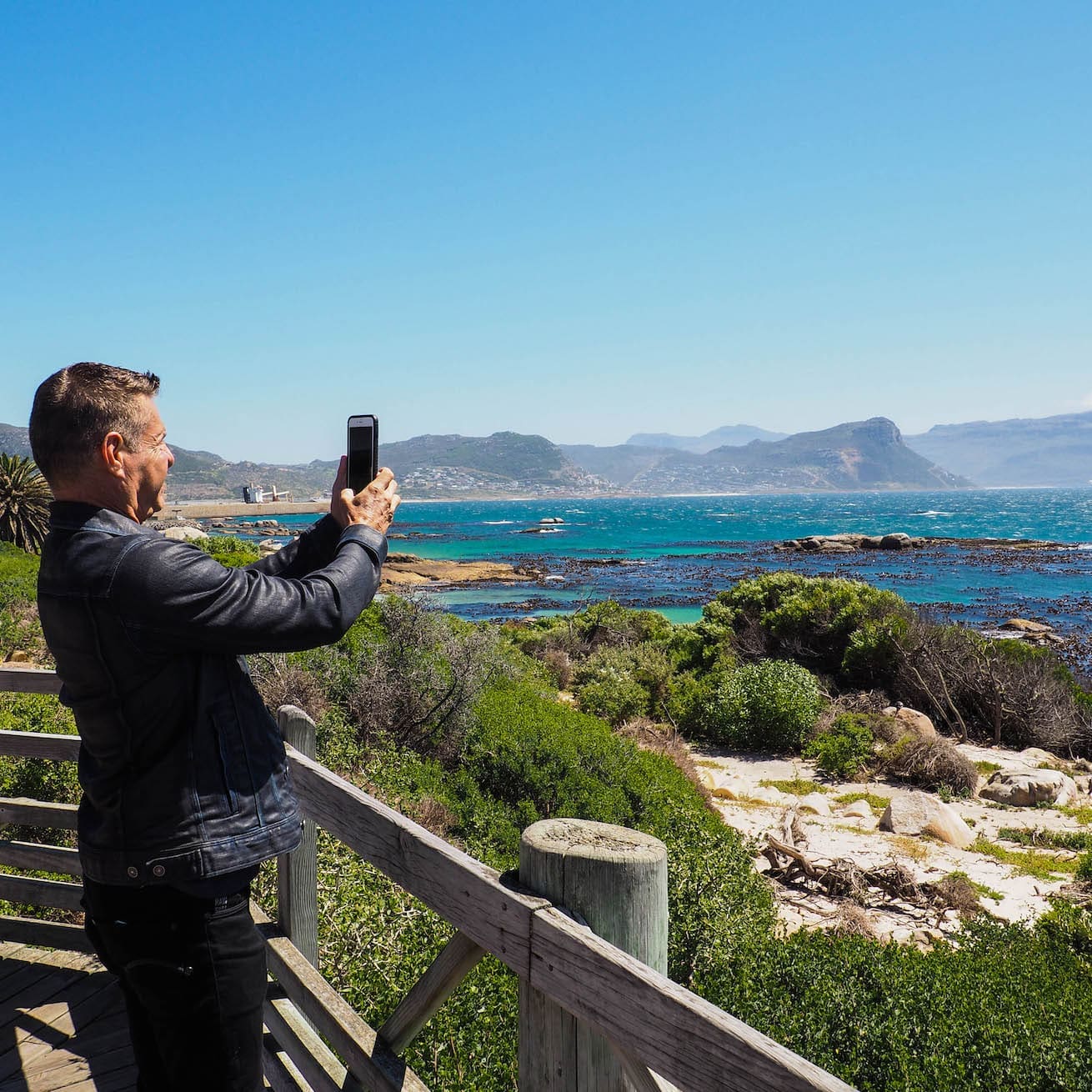 A gay traveller takes a photo of the Cape of Good Hope.