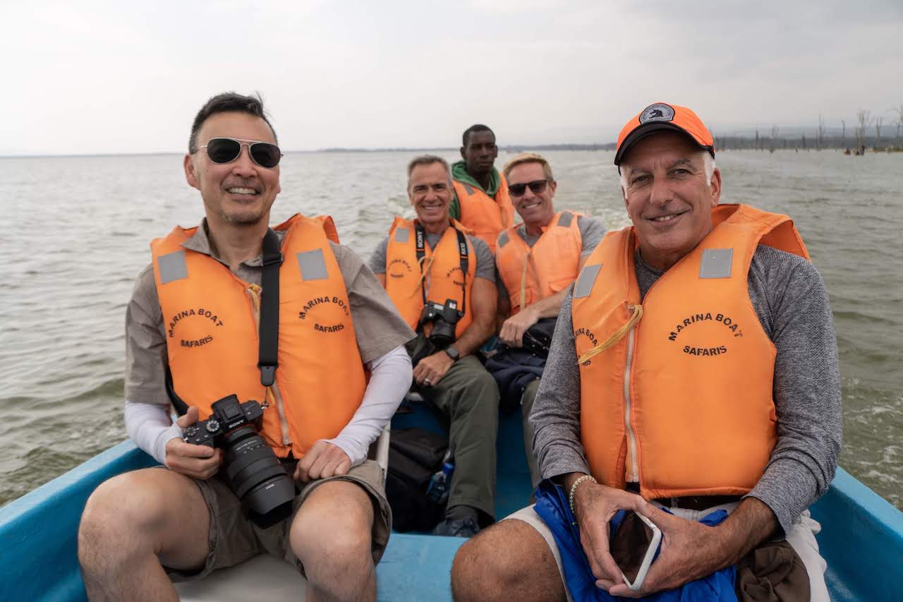 A group of travellers wearing life jackets aboard a boat on Lake Nakuru.