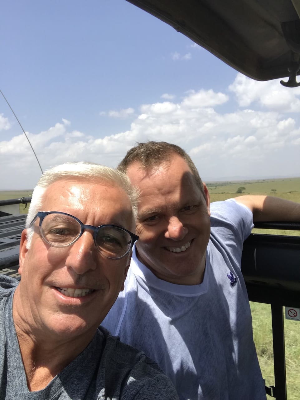 Two gay men take a selfie inside a safari vehicle in Kenya.