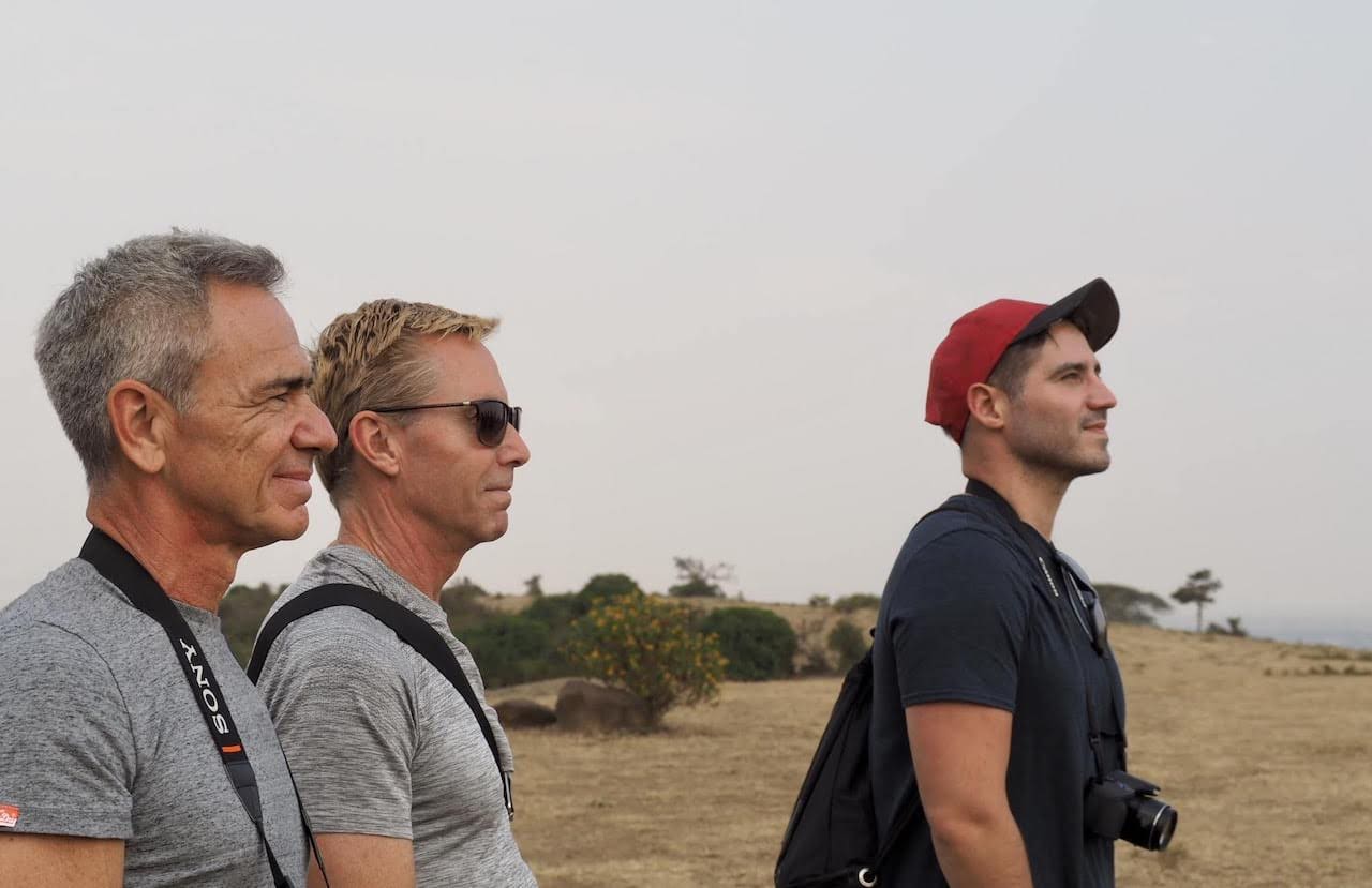 Three travellers look out over Kenya's endless savannah.