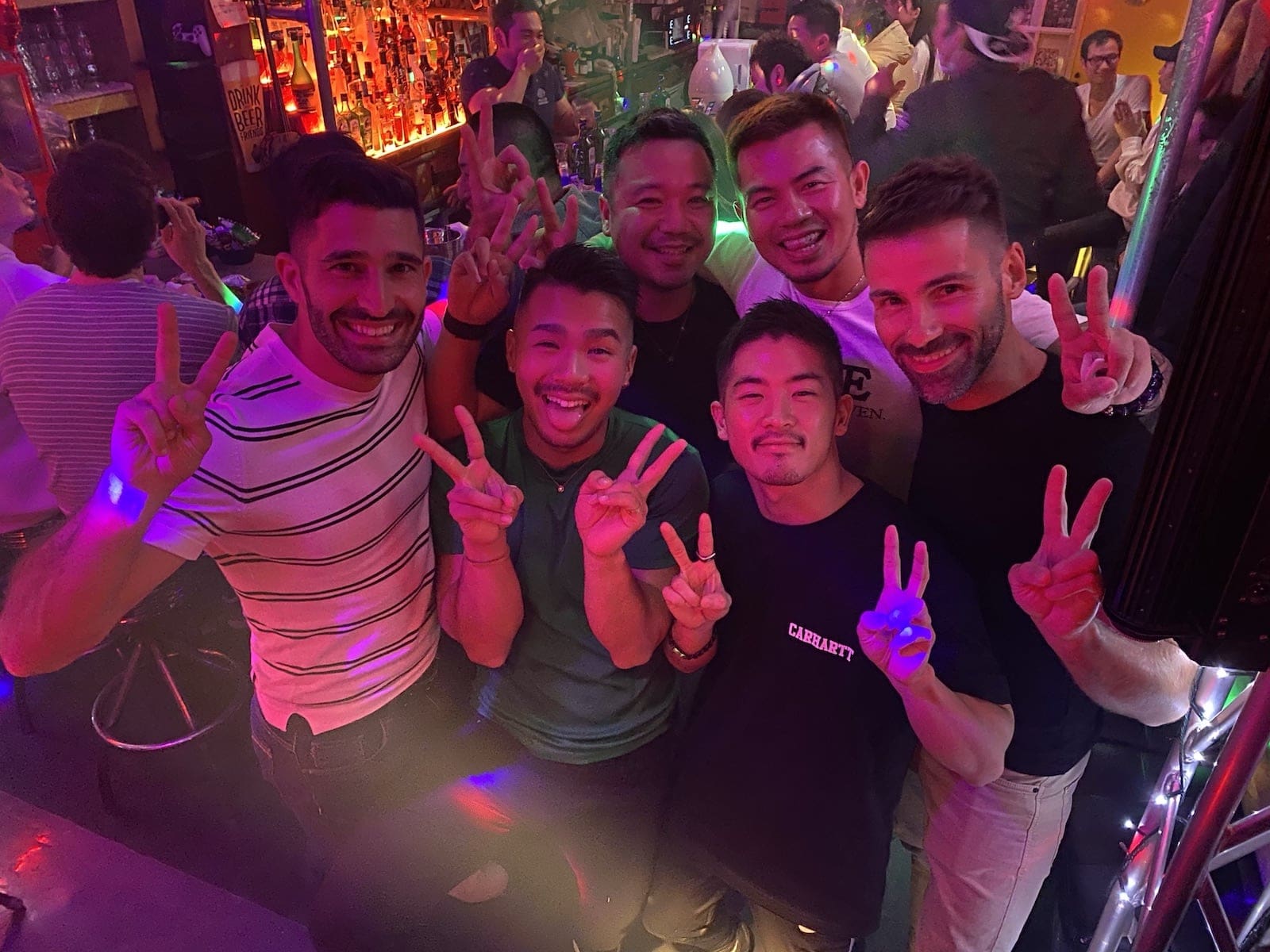 Nomadic Boys posing with a small crew of gay Japanese locals at a night club while exploring Tokyo's Shinjuku's Ni-Chōme neighbourhood.